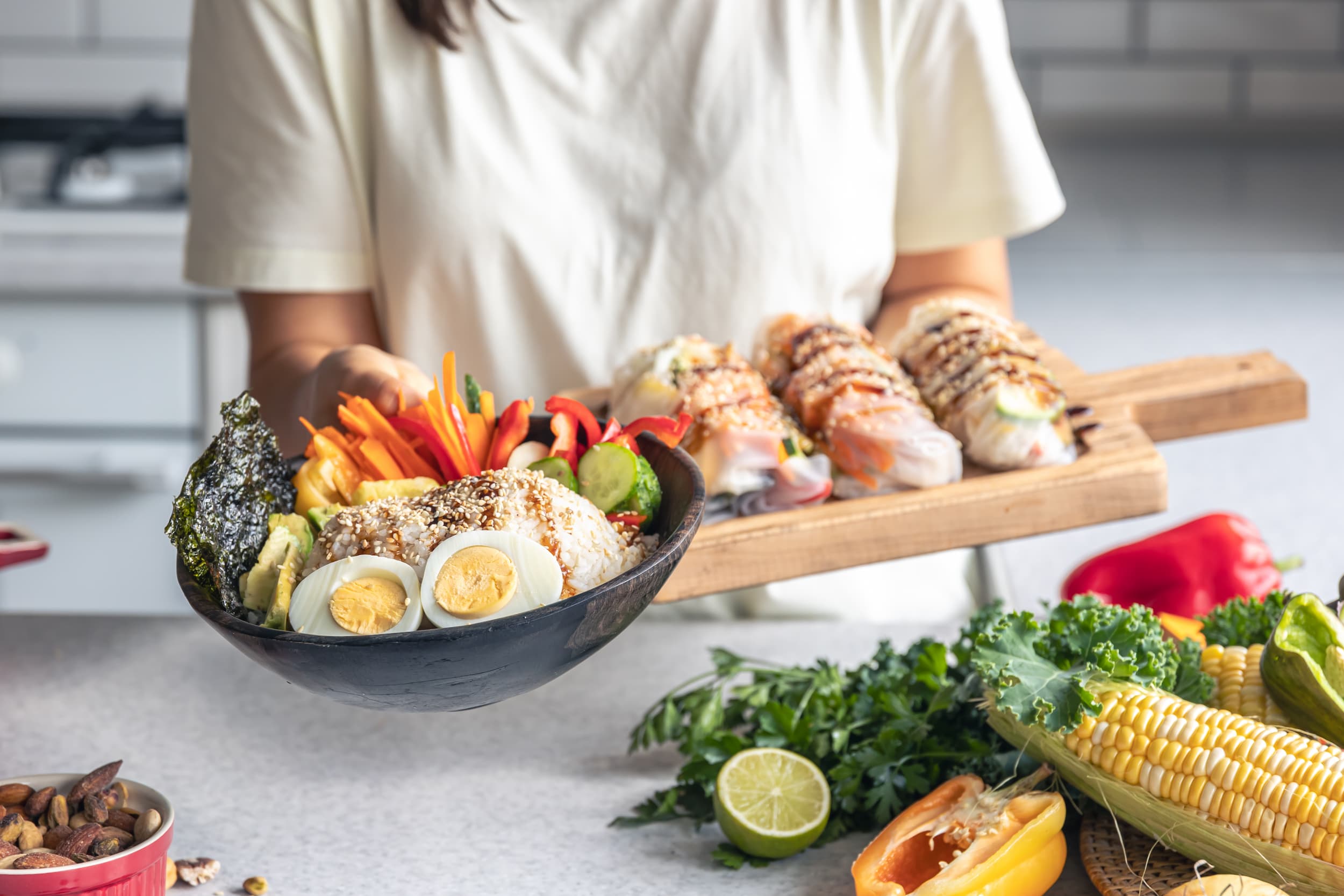 Fresh rice bowl and spring rolls served with colourful vegetables for healthy lunch.